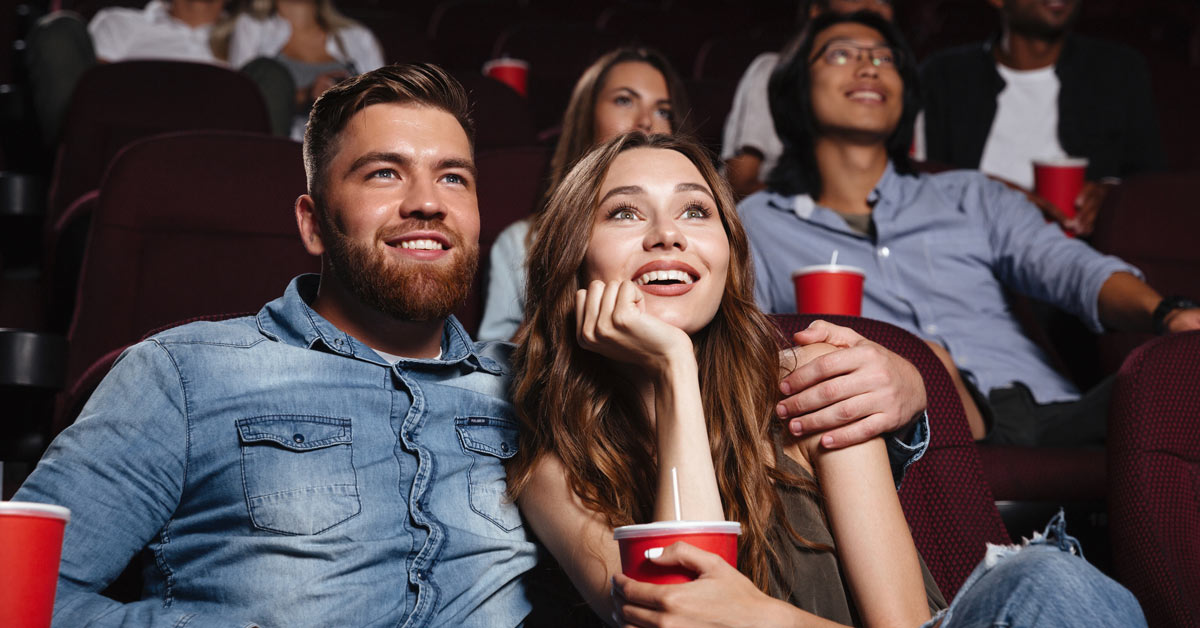 Glückliches Pärchen im Kino mit Popcorn